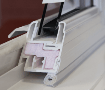 Close-up of Okna white vinyl window frame with internal insulation