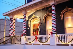 Night view of the Nelson Sanford House with holiday lights and glowing Marvin windows.