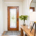 ProVia Signet Oak entry door with Aria decorative glass and caramel stain, shown in a Cleveland home interior with black Schlage hardware