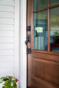 ProVia Signet Cherry entry door with Nutmeg stain and woodgrain texture, featuring black Schlage Addison hardware on a Cleveland home
