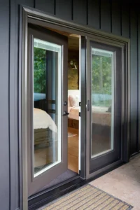 Rustic bronze hinged patio door with one active panel open, demonstrating easy access and a traditional patio door design.